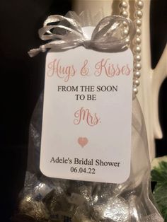 a white mug with a tag that says hugs and kisses from the soon to be mrs