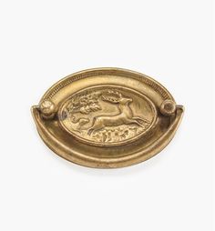 an antique brass plate with a horse on the front and side, against a white background