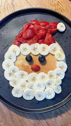 a pancake with bananas and strawberries in the shape of santa's face