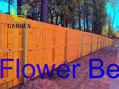 a wooden fence with the words flower bed in blue overlaying it's image