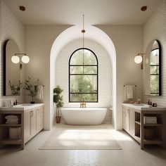 a large white bath tub sitting under a window in a bathroom next to two sinks