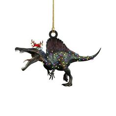 a dinosaur ornament hanging from a gold chain