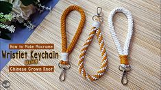 two lanyards with white and orange ropes on top of a wooden table next to flowers