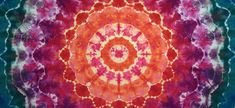 an orange, red and purple tie - dyed design on a blue background with white circles