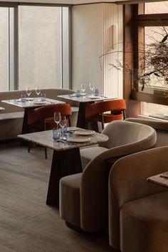 an empty restaurant with tables and chairs in front of large windows that look out onto the water