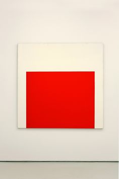 a red and white painting in an empty room