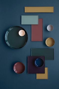 an assortment of plates and bowls on a blue surface