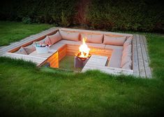 a fire pit in the middle of some grass