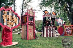 an assortment of carnival booths in the grass with trees and signs behind them that say, the pumpkin show