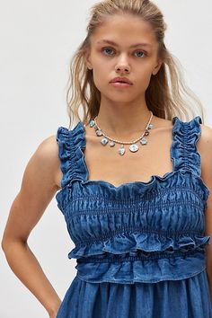 Frilled Michi Blue midi dress in a flowy, babydoll silhouette. Designed in a lightweight, soft denim featuring a ruffled square neckline and tank straps, frilled empire waistline and a self-tie bow at the back. Only at Urban Outfitters. Features Kimchi Blue Kenzie empire waist bow back denim maxi dress Smocked ruffle midi dress Square neckline and tank straps with ruffle trim Smocked bust with ruffle empire waistline Square back with self-tie bow detail Babydoll silhouette Midi length Adjustable straps Adjustable self-tie bow at waist Easy pull-on style UO exclusive Contents + Care 100% Cotton Machine wash Imported Size + Fit Model in Indigo is 5’8" and wearing size Small Measurements taken from size Small Length: 47" | Kimchi Blue Kenzie Empire Waist Bow Back Denim Maxi Dress in Indigo, W Kimchi Blue Dress, Denim Maxi Dress, Graphic Tee Dress, Ruffle Midi Dress, Denim Maxi, Empire Waistline, Bow Back, Urban Dresses, Tie Bow