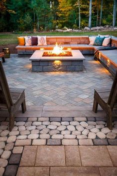 an outdoor fire pit surrounded by benches and stone pavers is featured in this post