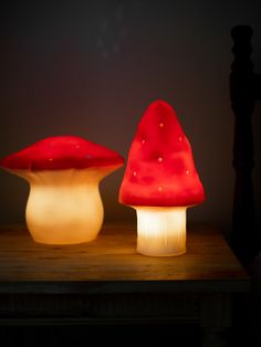 two mushroom shaped lights sitting on top of a wooden table