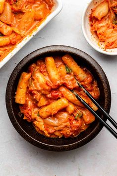 two bowls filled with pasta and some chopsticks