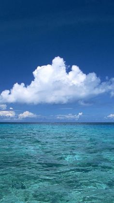 the water is very clear and blue with clouds in the sky