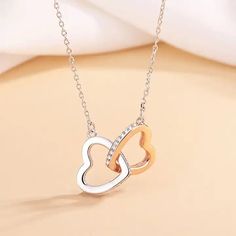 "Embrace the season of love with our signature interlocking hearts necklace. A symbol of unbreakable bonds and eternal affection, this exquisite piece is designed to capture the essence of Valentine's Day and the promise of a love that lasts a lifetime. 💕 Pendant Perfection: Two delicately interlocking hearts form the centerpiece of this necklace, each heart representing the unique journey of love. Crafted with polished stainless steel, the hearts shine brilliantly, reflecting the light of your love story. 💖 Limited Edition: As a Valentine's Day special, this necklace is a limited edition release. Don't miss the opportunity to own or gift this exclusive token of love! Product Specs: Base Metal: Stainless Steel Color: Rose Gold and Silver Chain Length: 16\" + 2\" extension chain with a lo Double Heart Necklace With Clavicle Chain For Anniversary, Double Heart Clavicle Chain Necklace For Mother's Day, White Gold Double Heart Necklace As Gift For Mom, Double Heart Necklace For Valentine's Day Gift, Double Heart Clavicle Chain Necklace For Anniversary, White Gold Necklace For Valentine's Day Gift For Mom, White Gold Heart Necklace For Mother's Day, White Gold Double Heart Necklace For Her, Double Heart Necklaces With Adjustable Chain For Anniversary