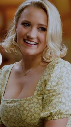 a woman with blonde hair smiling and holding a white frisbee in her hand