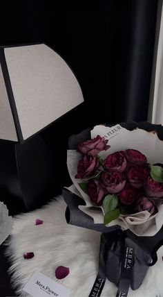 a bouquet of roses sitting on top of a table next to a black and white lamp