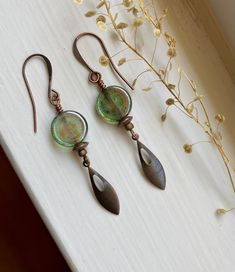 Details & measurements: ~ Small lightweight antique copper pointed teardrop dangle charms (22 x 6mm) paired with Czech glass coin beads in dusty blue color with mossy green marbling and a lovely fire polished finish (12mm round)  ~ Accented with tiny mud-colored spacer beads and saucer-shaped copper spacer beads (6 x 2mm) ~ They hang from antique copper ear wires ~ Earrings hang just over 2 1/4" long ♡ Packaged safely & sustainably in a kraft box with cotton ribbon & dried organic florals. This makes for a beautiful gift, or something pretty for yourself! All packaging materials are zero waste and also reusable. ♡ As well, we always aim to ship with plastic-free packing materials. Sustainability is an integral part of our lives, and we bring that same dedication to our small business. Earthy Blue, Dusty Blue Color, Earthy Jewelry, Mossy Green, Cotton Ribbon, Moon River, Dangle Charms, Wire Earrings, Etsy Earrings Dangle