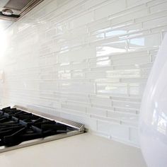 a stove top oven sitting inside of a kitchen next to a white tiled countertop