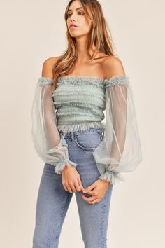 This stunning top features a sheer sleeve, smocked bodice with ruffle detail and off-the-shoulder silhouette. Pair with our Kan Can High Rise Skinny Jeans for a trendy look. Tulle Top, Tulle Sleeves, Sheer Sleeves, Ruffle Top, Cute Tops, Smocking, Off The Shoulder, Bodice