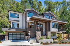 a two story house with lots of windows on the top floor and stairs leading up to it