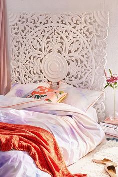 the bed is made with white sheets and pink blankets on it's headboard