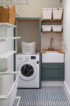 a washer and dryer in a small room with blue floor tiles on the walls