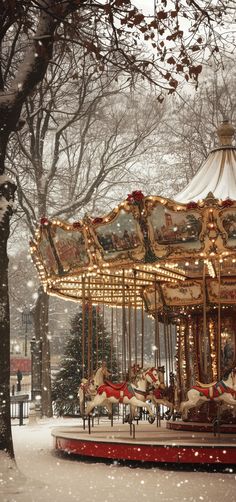 a merry go round in the snow near trees