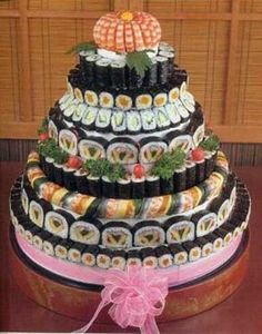 a multi layer cake decorated with sushi rolls and pumpkins on the top tier