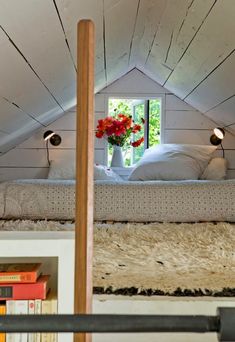 there is a bed with white sheets and pillows in the attic