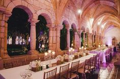 the tables are set up in an old building for a formal function with candles and centerpieces