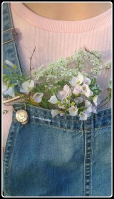 a person wearing overalls with flowers in their pocket and a badge on the back