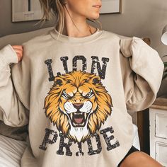 a woman wearing a lion sweatshirt with the words lion pride printed on it