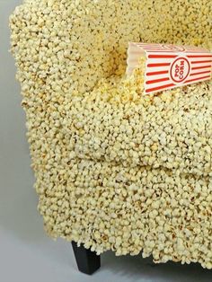 a popcorn box sitting on top of a chair made out of corn flakes