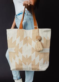 You'll be ready for your next getaway with our tote collection! This cream and tan Aztec inspired large tote is just what you need for an upcoming vacation, or for running errands.  Cream and tan Aztec inspired tote Tan pom tassel detail Leather suede straps Measures 16" x 6" x 16" Designed in the U.S.A. Produced in India. 100% Cotton Lining: 100% Polyester Flannel Sweatshirt, Blouses Vintage, Knitted Hats Kids, Knit Hat For Men, Knit Jewelry, Everyday Tote Bag, Dangle Necklaces, Everyday Tote, Knitting For Kids