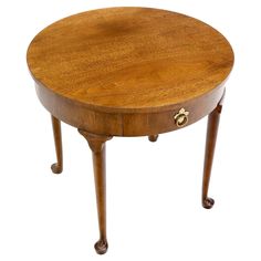 a round wooden table with two legs and a drawer on one end, against a white background