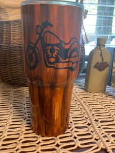 a close up of a wooden cup on a table with other items in the background