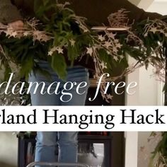 a person standing on top of a chair near a fire place with the words, how to manage free garland hanging hack