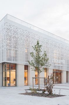 the building has many windows on it and is made out of white perforsants