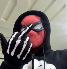 a person wearing a spider - man mask and black gloves with white stripes on it