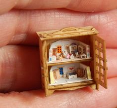 a miniature doll house in the palm of someone's hand with it's door open