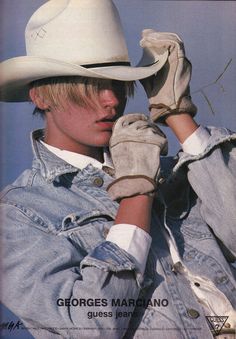 a young man wearing a cowboy hat and gloves