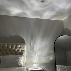 a room with a bed, mirror and lamp in it