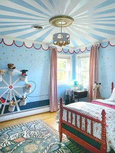 a bedroom decorated in blue and pink with a ferris wheel painted on the wall