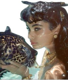 a woman is holding a leopard in front of her face