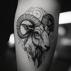 a black and white photo of a ram tattoo on the calf's leg,