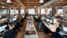 an office filled with lots of desks and computer monitors on top of each other