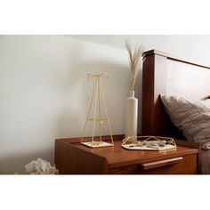 a bed with a wooden headboard and night stand next to it on top of a dresser