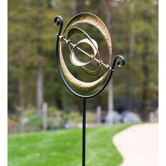 a metal sculpture in the middle of a grassy area