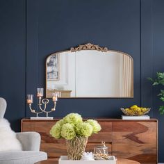 a living room filled with furniture and a large mirror on the wall over a coffee table